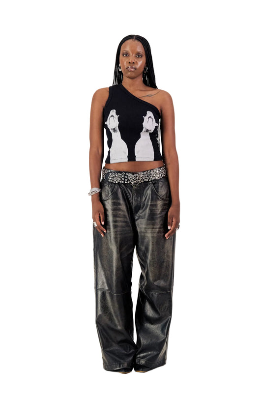 Woman wearing a black sleeveless top with white graphics and black leather pants on a white background