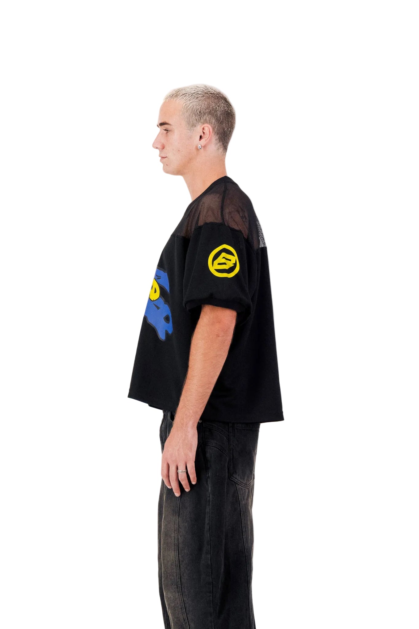 Person wearing a black oversized t-shirt with colorful designs on a white background