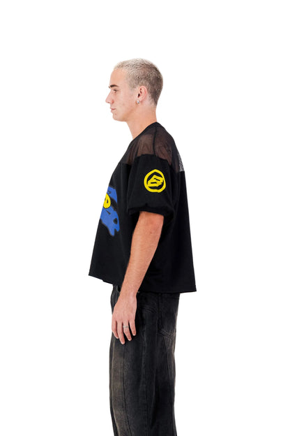 Person wearing a black oversized t-shirt with colorful designs on a white background